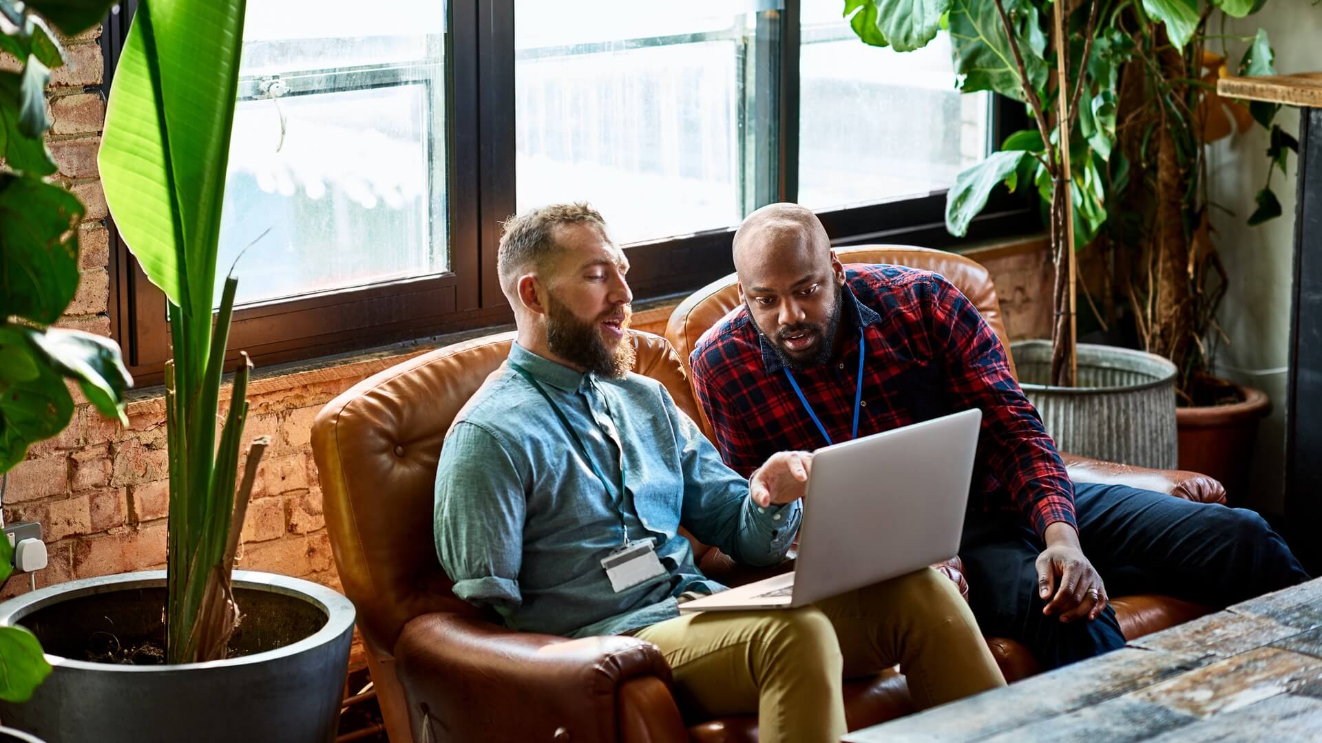 Two colleagues sitting in front of a laptop having a discussion