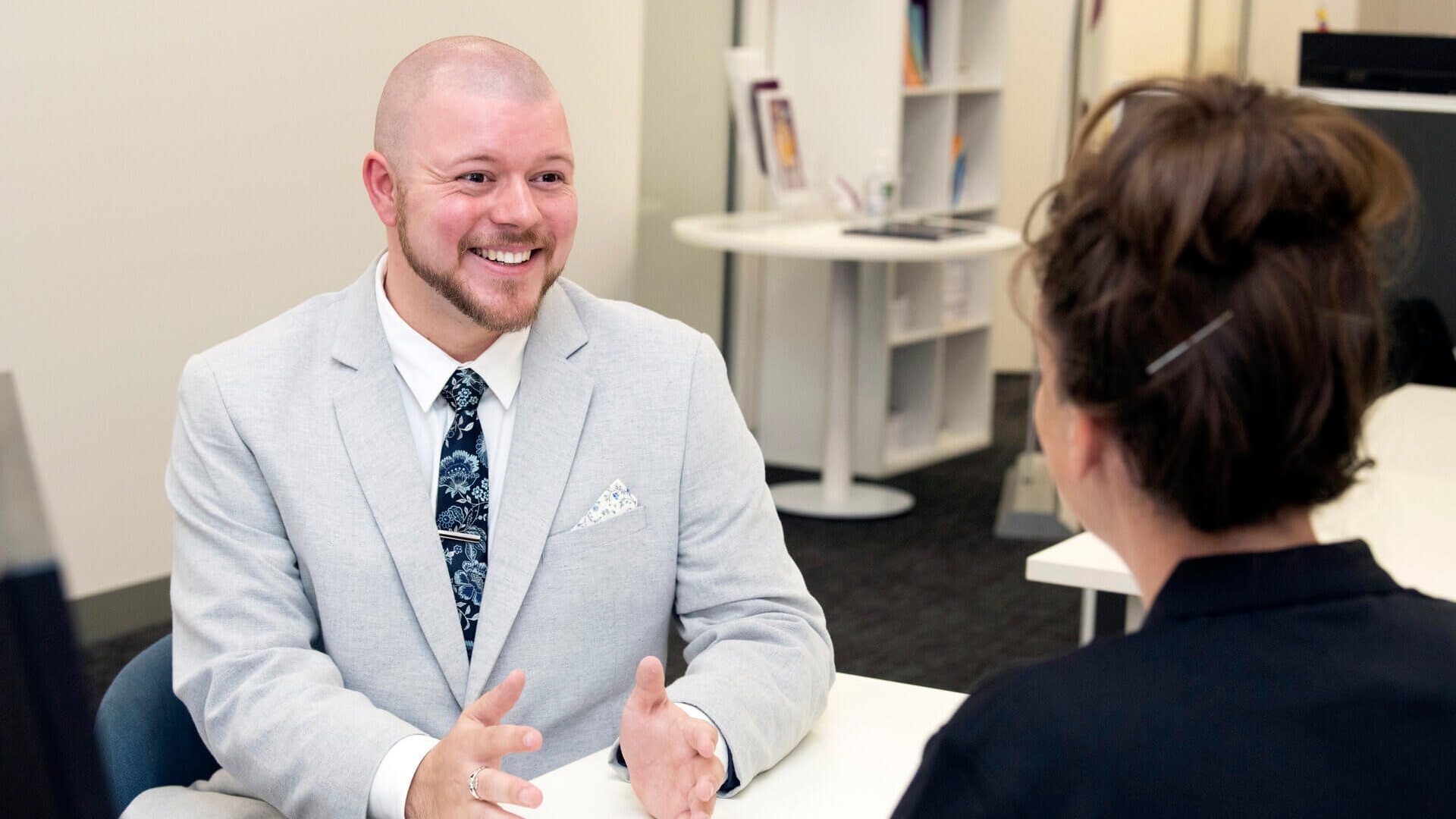 DES participant Mitchell sits at desk talking to his APM Employment Consultant