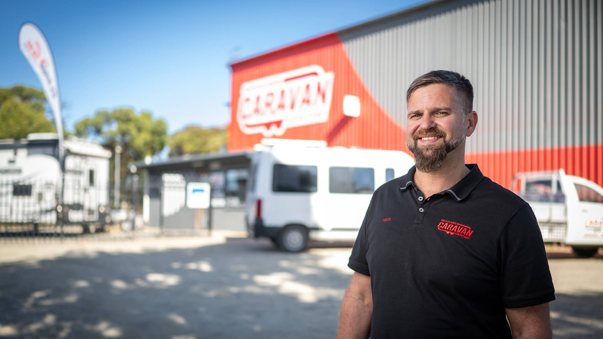 Employer Amos smiles outside the business