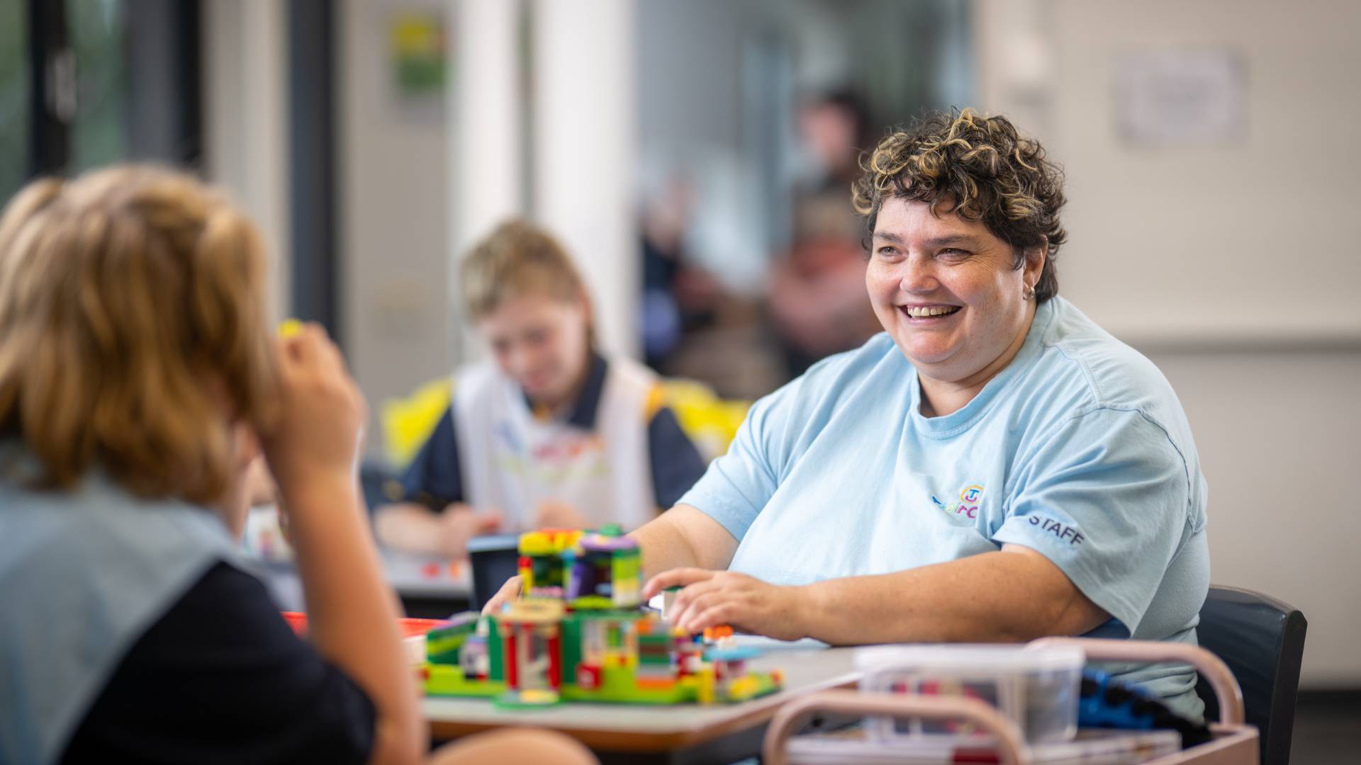 Natalie sits with children in an afterschool class