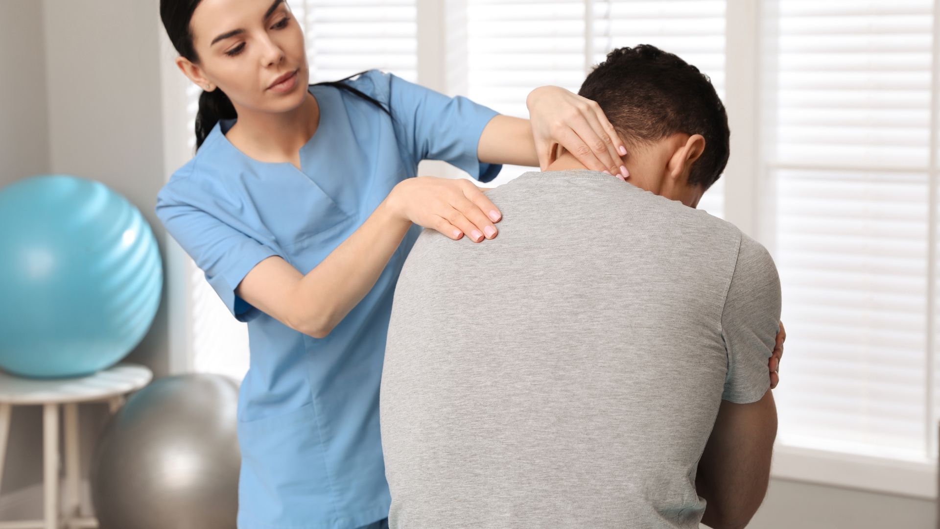 A man is examined by a female doctor for a back condition