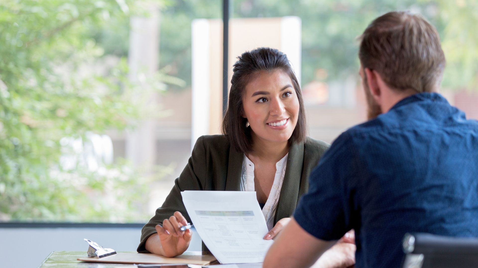 Employment consultant reviewing a document with a job seeker in a one-on-one meeting, in a supportive and professional setting