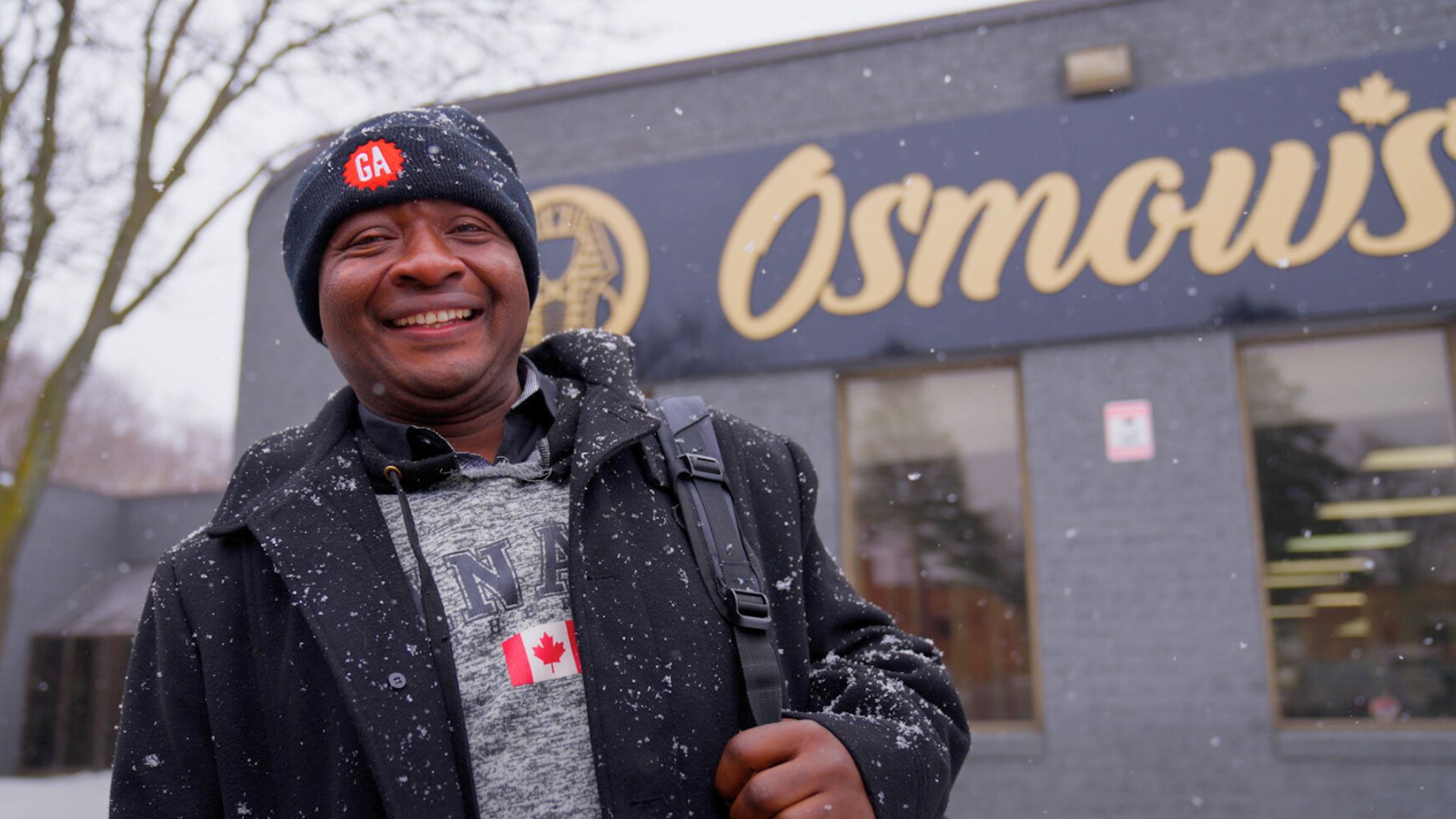 Felix standing outside Osmow’s restaurant in Canada, where he began his new job with support from WCG Services and Collège Boréal.