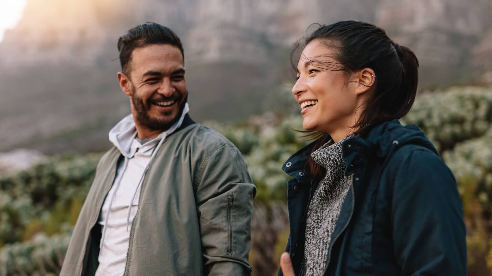 Two people chat happily as they walk outdoors