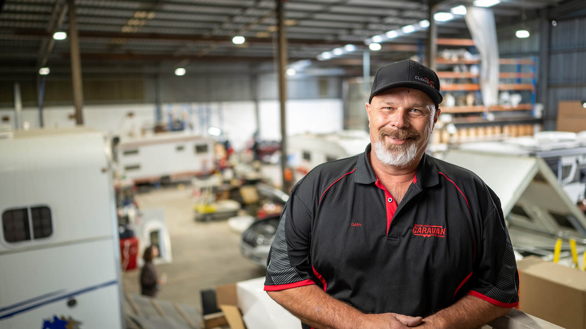 DES participant Gary in a work cap and uniform smiles in a warehouse