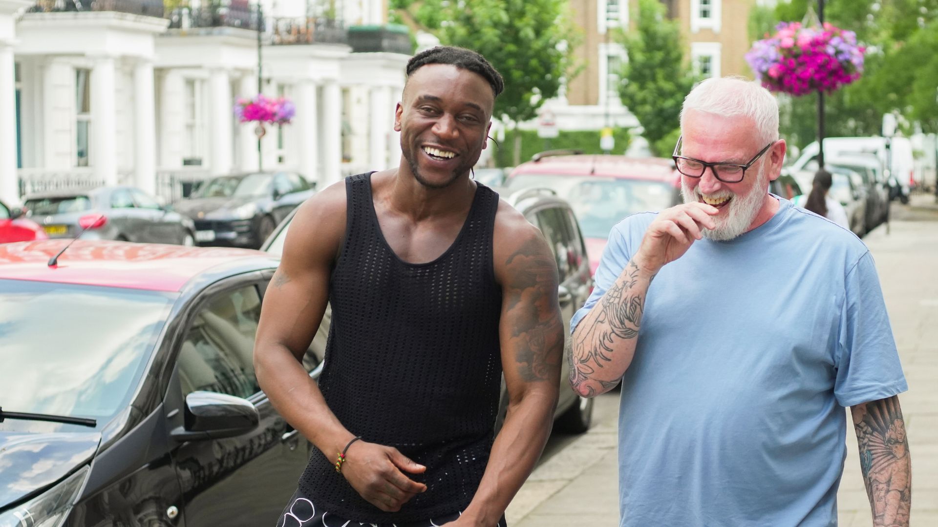Khalif walking along a residential street with an advisor, representing the support that helped him transition from living in a tent to stable housing and training opportunities.