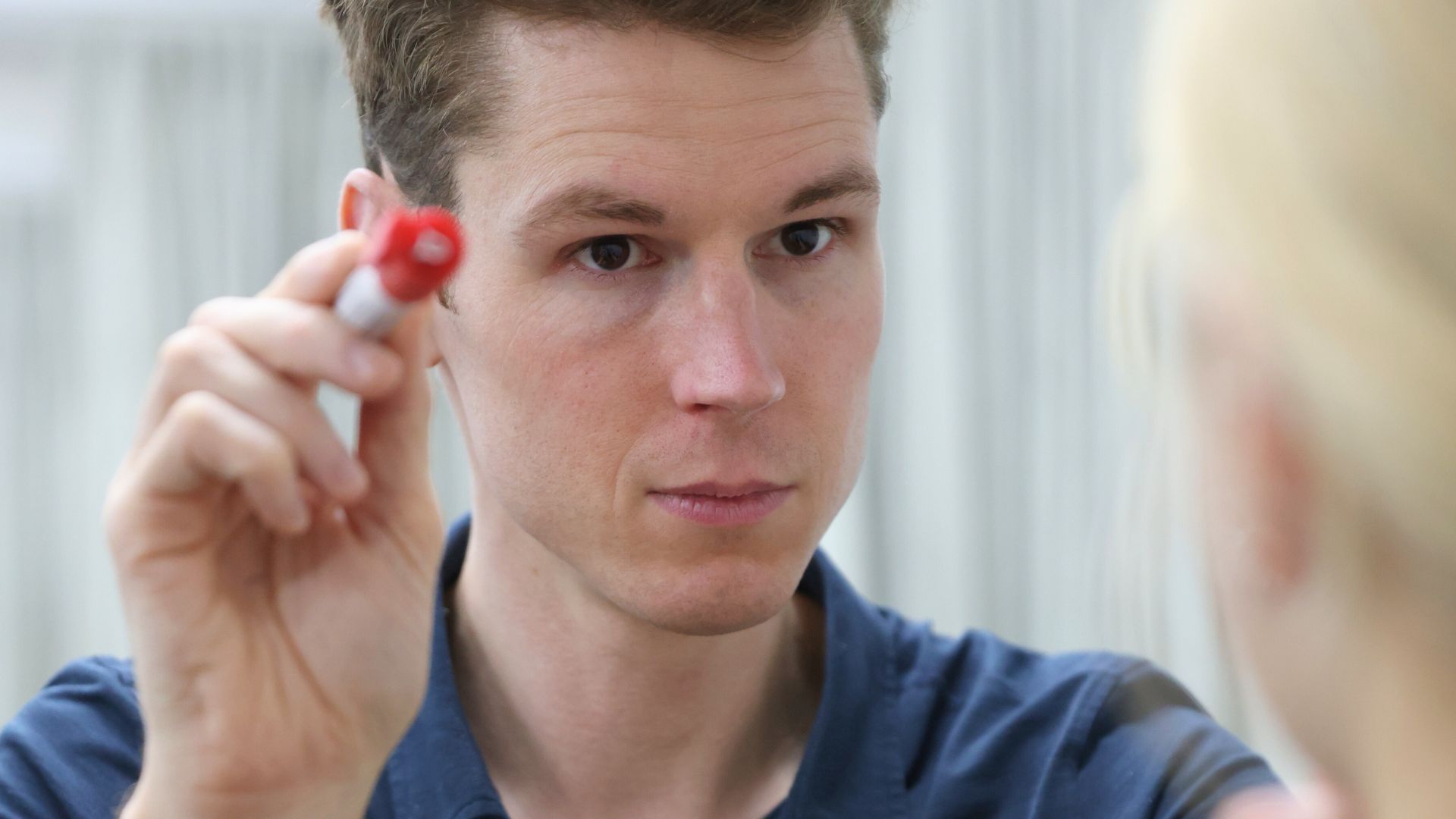 Physiotherapist performing a vision-based assessment using a pen to track eye movement, supporting accurate diagnosis and evidence-based treatment for dizziness and vertigo.
