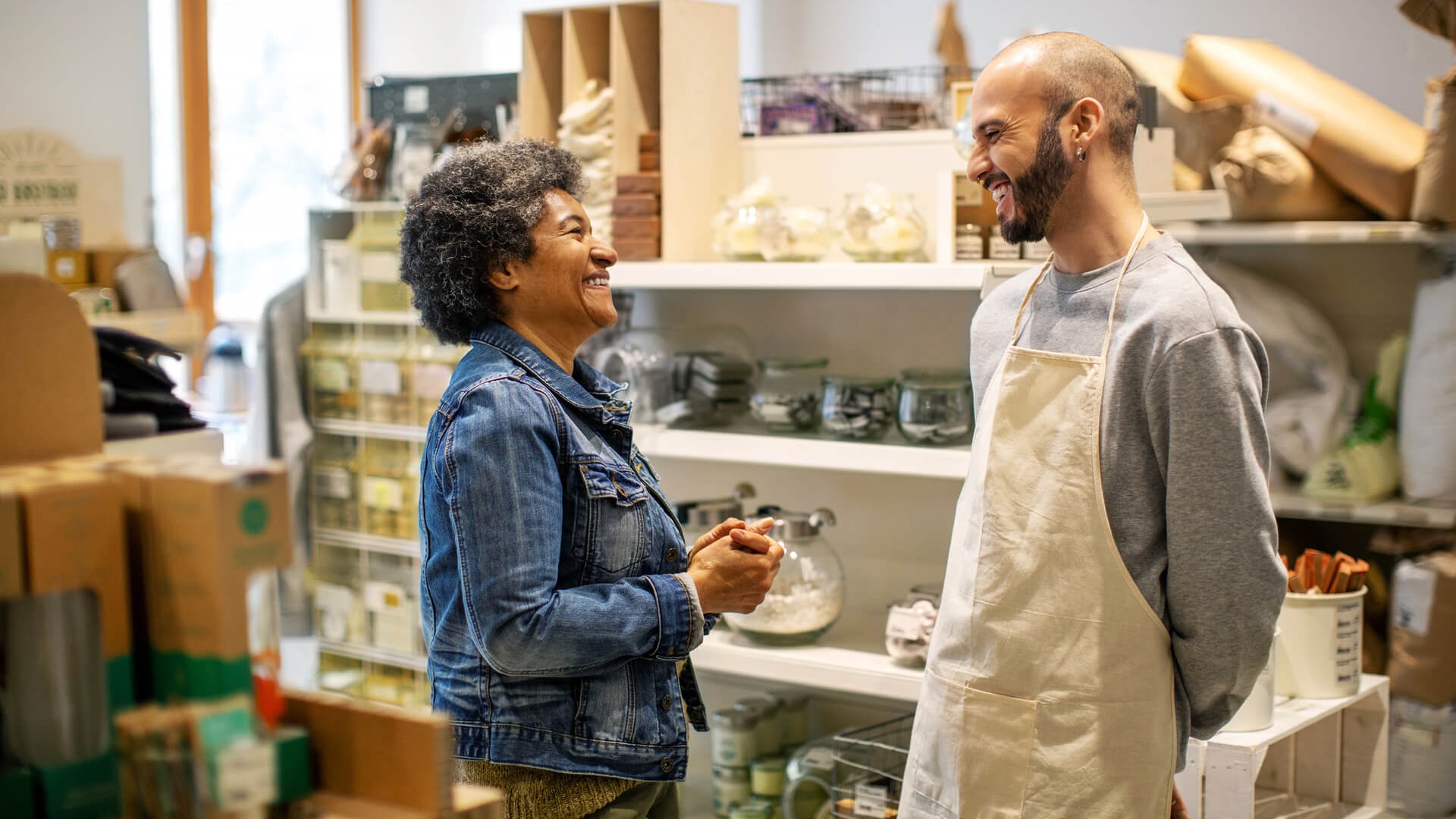 Two co-workers having a conversation in a store room