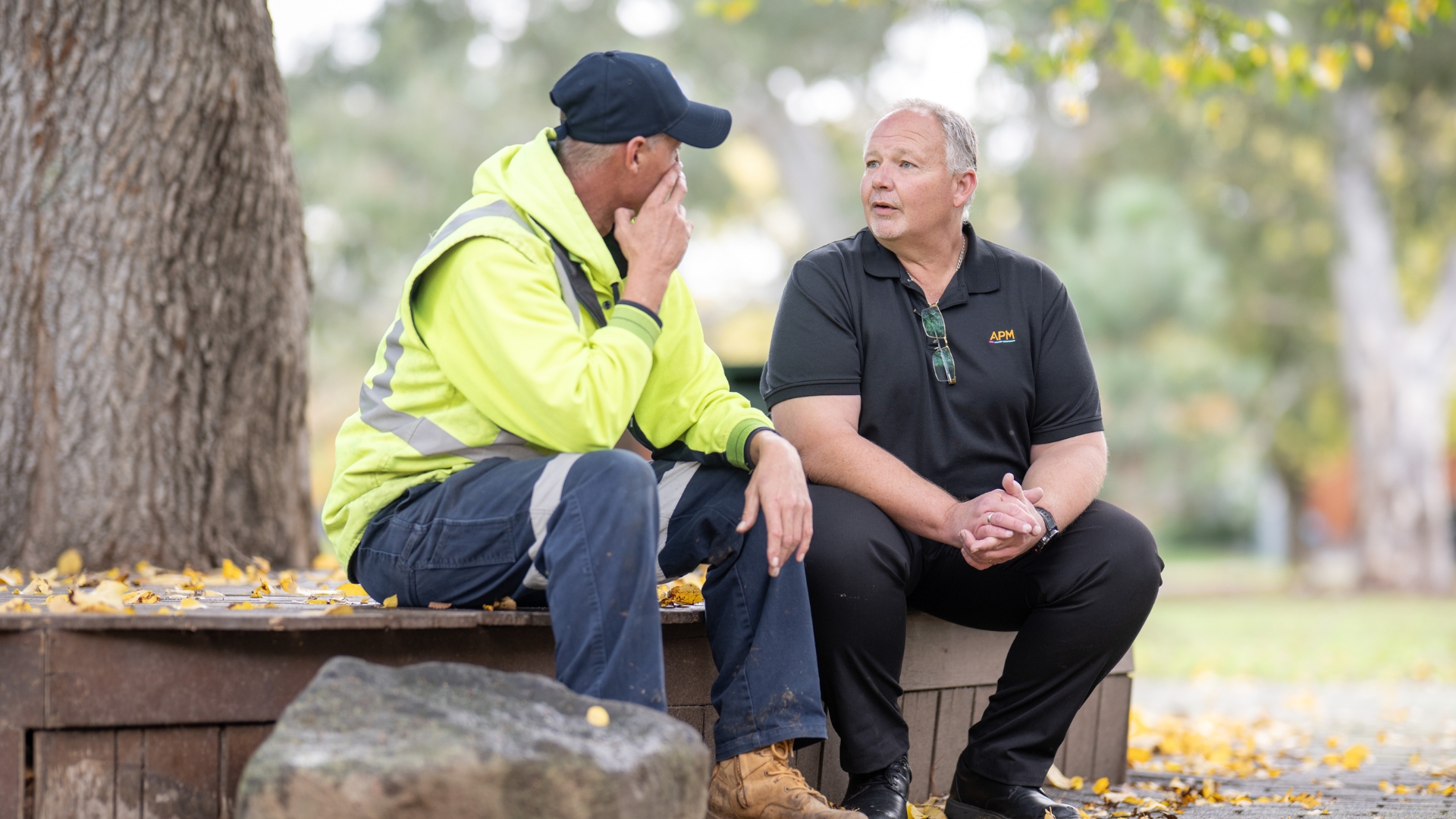 Paul meeting with an employment consultant outdoors to discuss workplace goals and progress, showcasing personalised employment support delivered through Inclusive Employment Australia and APM Employment Services.