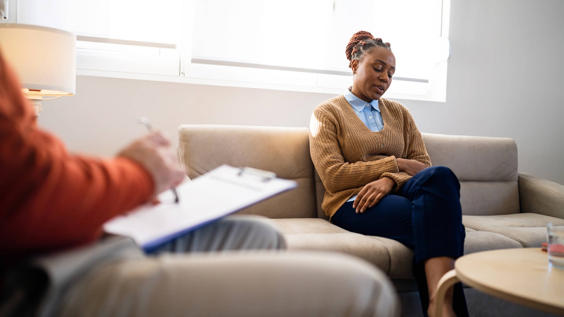 A woman sitting on a couch in a therapy session