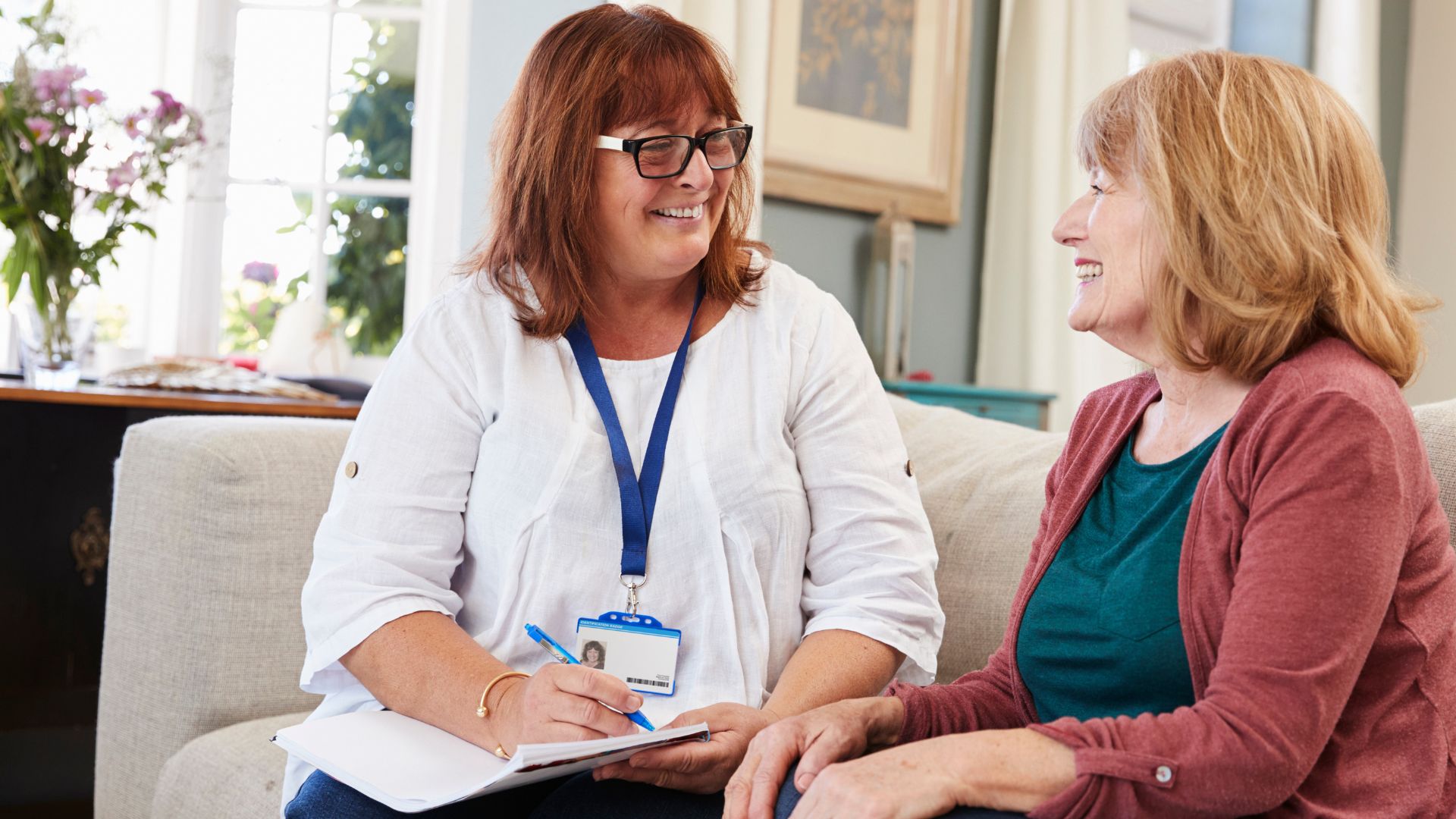 A disability support worker sits with a client