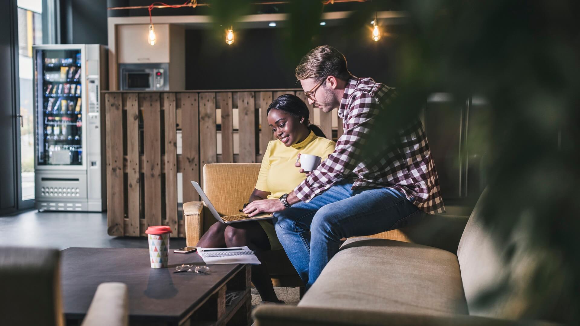 Two people in a café working together on a laptop