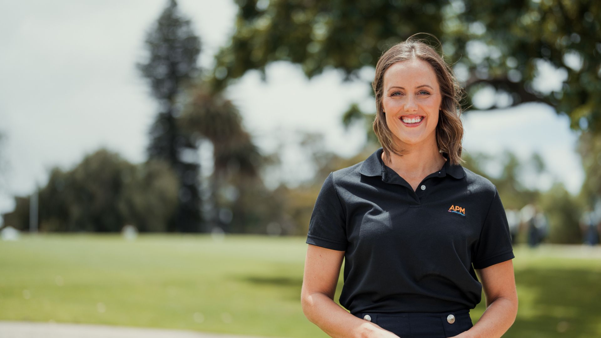 Ellie Cole between two APM team members in black polos