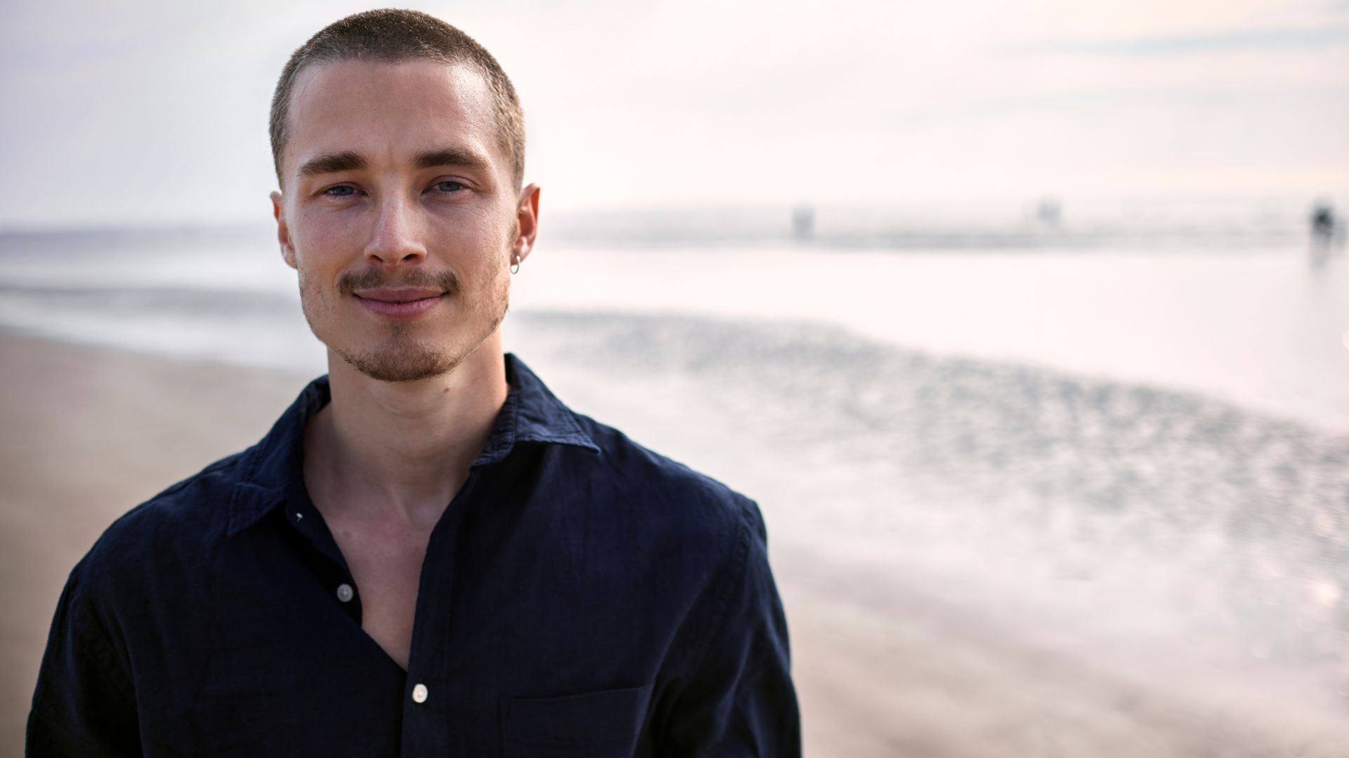 Person standing on a beach, representing self-care and mindfulness strategies for living with schizophrenia.