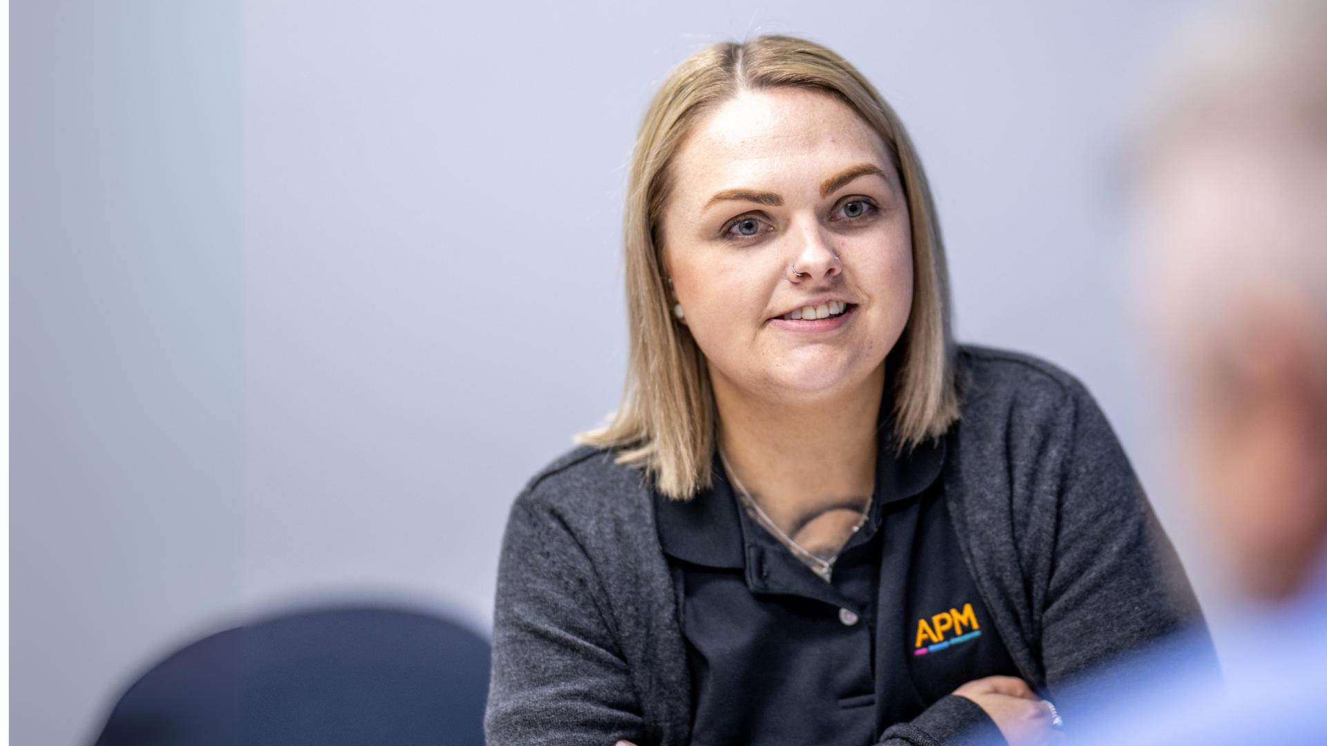APM consultant Amelia sits opposite a man in a blue shirt