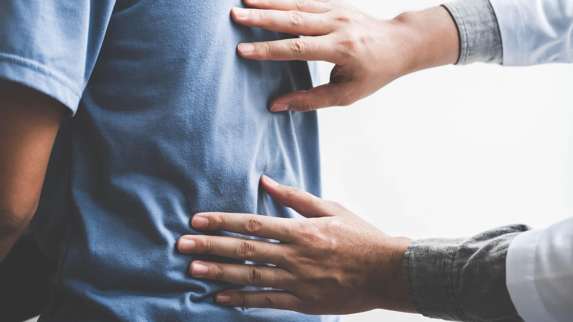 A doctor examining a man's back