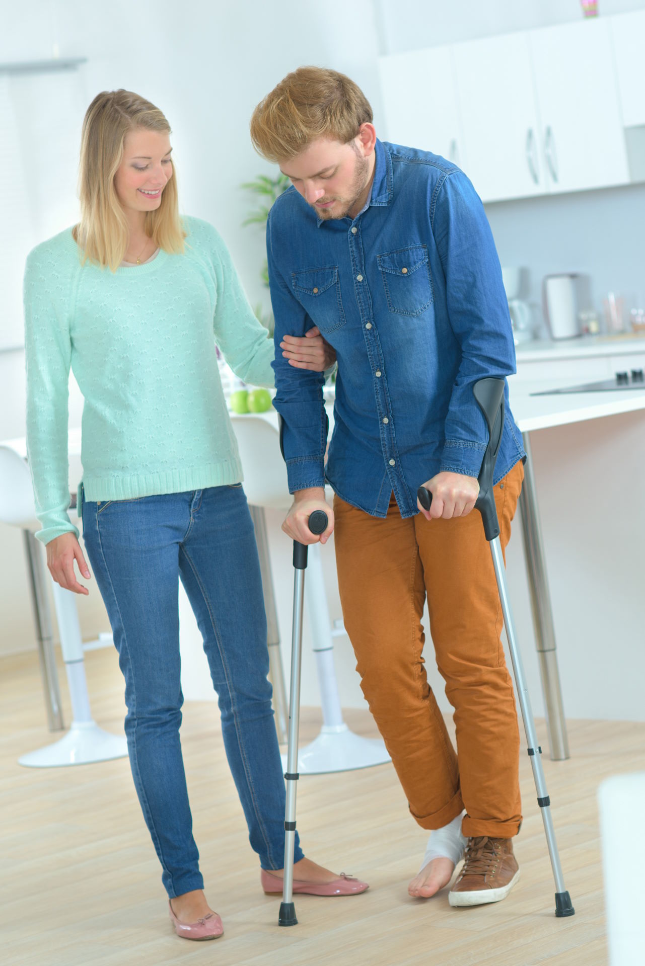 woman helping a man with crutches