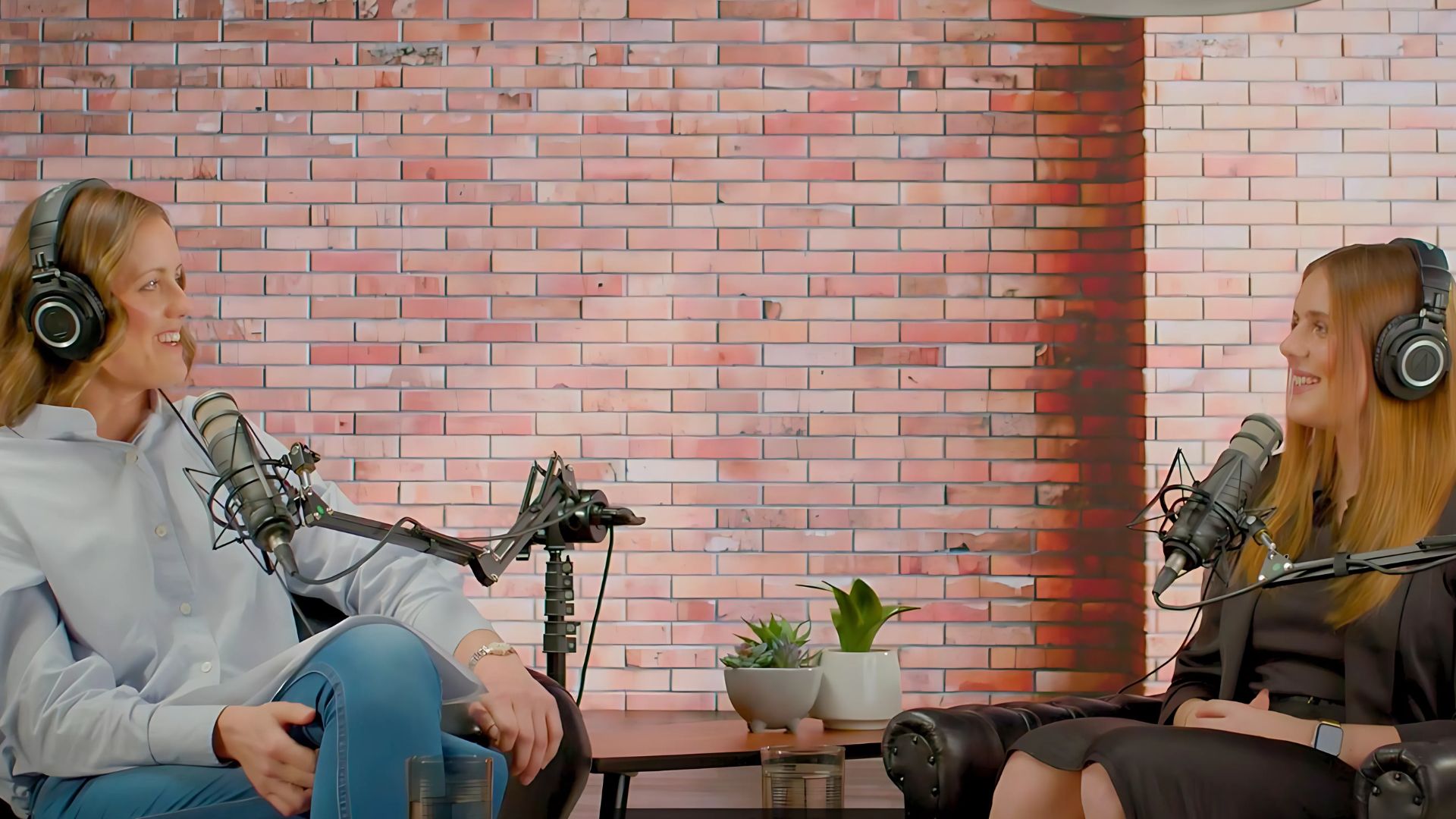 Lyndsey sits with a microphone opposite Ellie Cole