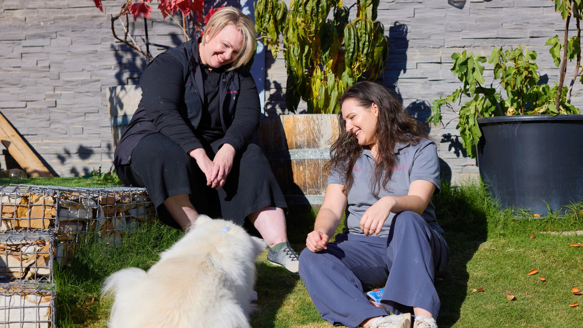 Vicki and Ciana sit with a dog outside