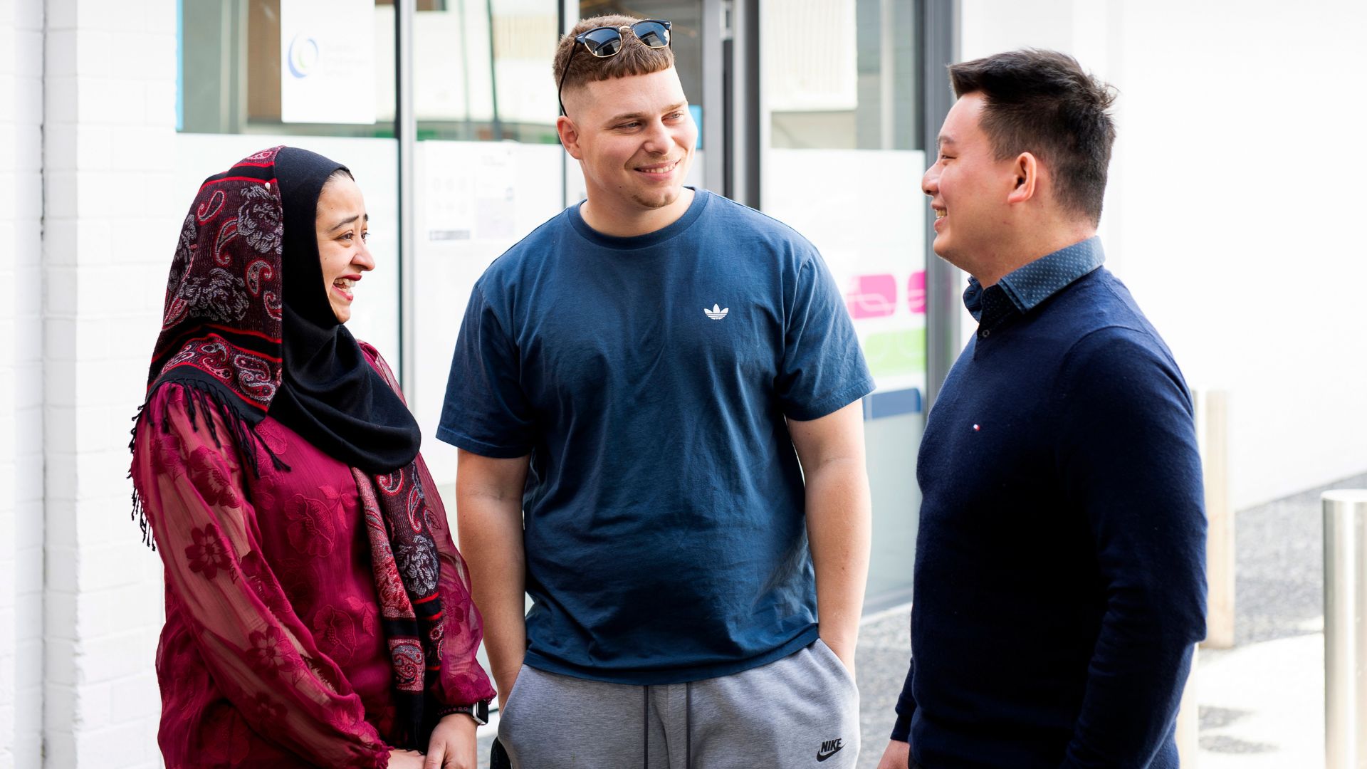 DES participant talking to APM team member in a head scarf and blue sweater outside