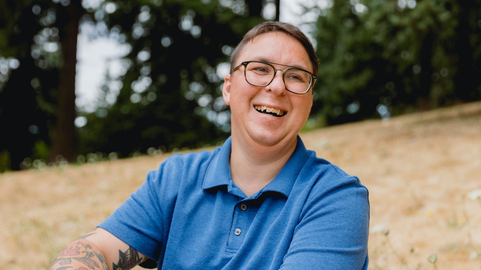 a man smiling in a blue top