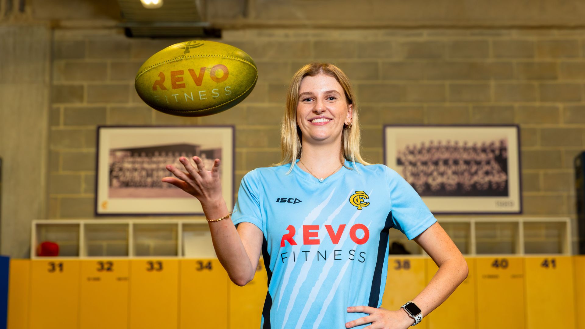 Annie standing indoors with a football during a Claremont Football Club training session.